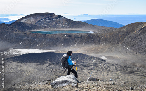 Obraz na płótnie Female backpacker looking at the views of Blue Lake and Mt Taranaki in the far distance. Tongariro Alpine Crossing, Tongariro National Park. New Zealand. w salonie