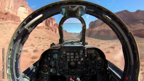 Cockpit view of a fighter jet flying through a desert canyon, showcasing rugged rock formations and blue sky