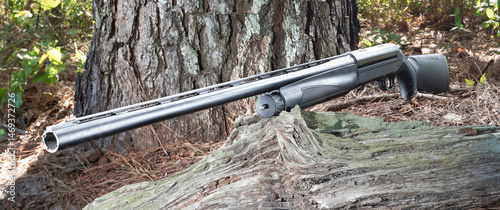 Black semi-auto hunting shotgun in a forest