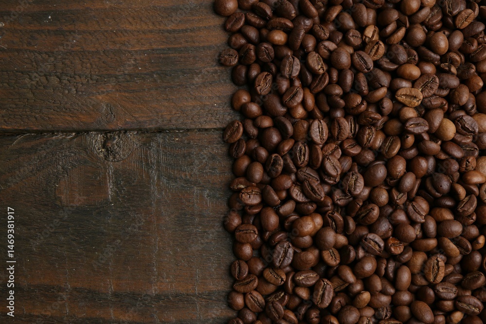 Fototapeta premium Aromatic coffee beans on wooden table, top view. Space for text
