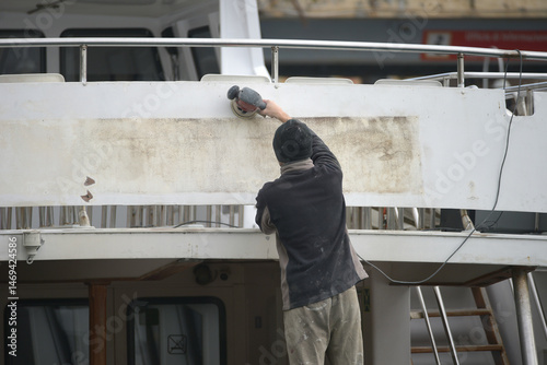 Operaio Intento nella Manutenzione dello Scafo di un'Imbarcazione photo