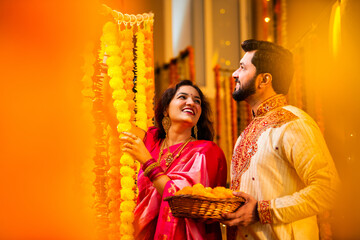 Indian couple Tie Marigold Garland for Diwali Home Decoration in Festive Attire