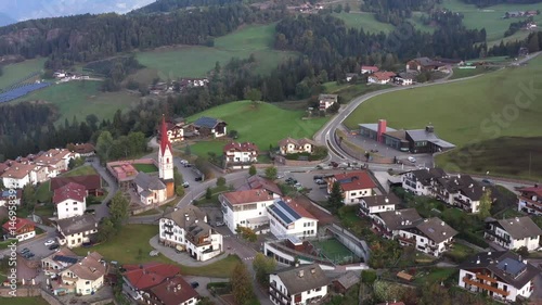 Aussicht auf ein Dorf inmitten grüner Wiesen und Wälder mit Bergen im Hintergrund, Video, Drohne, Drohnenaufnahme, Vöran, Bozen, Trentino, Südtirol, Italien
