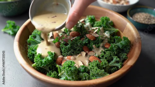Preparing a nutritious kale salad with almonds and creamy dressing for healthy eating