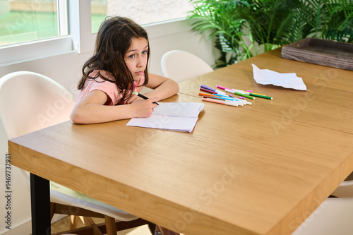 Young Girl Drawing with Colorful Markers at a Wooden Table at Home