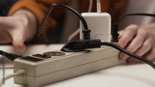 Man turning-off plugs and red push button to turn on power strip. Save electricity