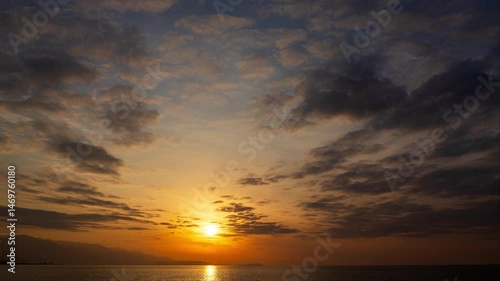 黄金の光と動く雲が織りなすドラマチックな夕焼け空のタイムラプス