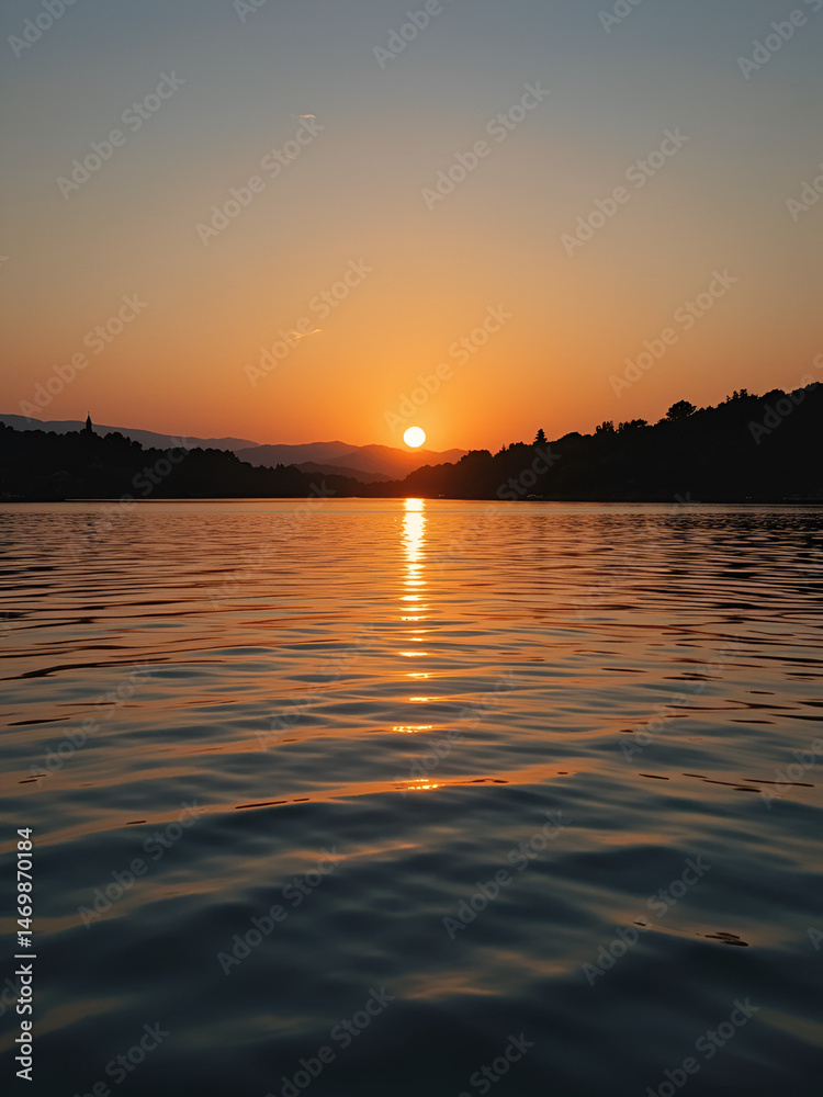 Naklejka premium Sunset reflected in water with ripples