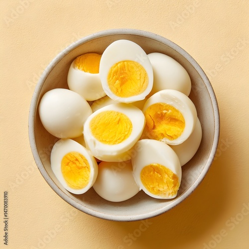 A bowl of perfectly boiled eggs on a bright yellow background