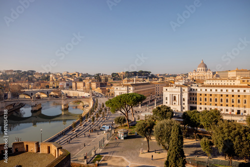 A sweeping view over Vatican City and St. Peters Basilica from Castel Sant Angelo, capturing the layout of Via della Conciliazione flanked by historic buildings and Roman pines photo