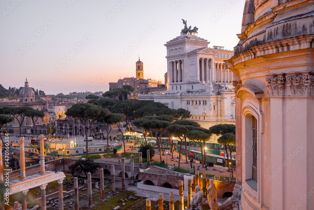 Obraz premium Scenic view of a historic dome and ancient Roman ruins glowing in the sunset light. The iconic Altare della Patria rises in the background above Romes evening skyline