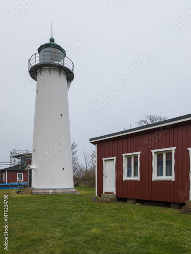 White lighthouse and red wooden house in Smygehuk, Sweden.