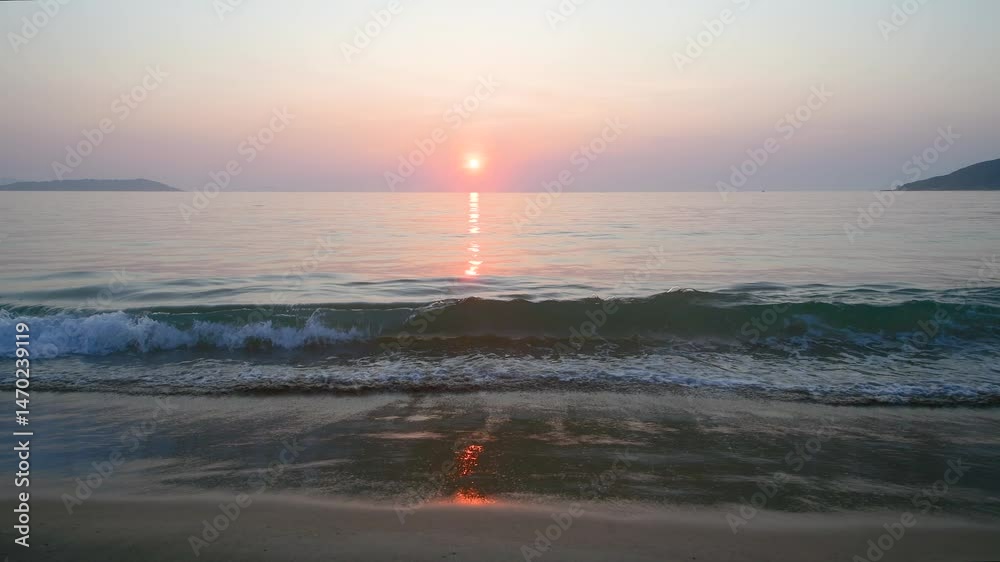 Beautiful sunrise over the calm sea reflecting on the sandy shore