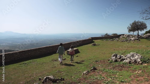 Children Exploring Mountain Meadow, Taking a Break on Stone Bench