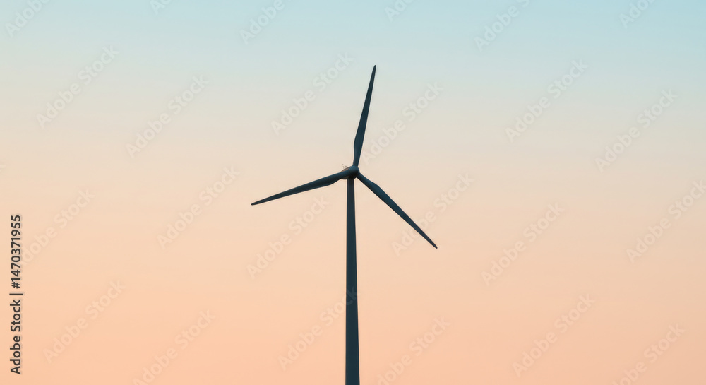 Obraz premium Wind turbine against a tranquil sunset sky