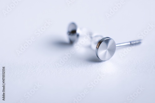 Close-up of a pair of modern, minimalist stud earrings.