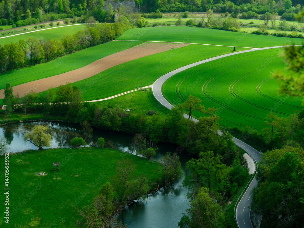 Countryside landscape showcasing winding roads and lush green fields during daylight hours Countryside landscape showcasing winding roads and lush green fields during daylight hours