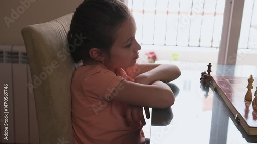 Young Girl Contemplating Her Next Move in a Chess Game at Home
