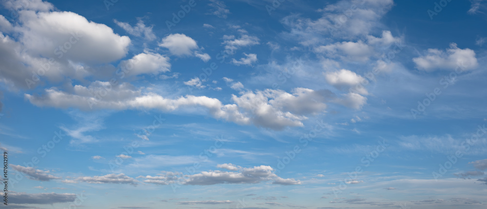 Fototapeta premium heaven sky is blue with a few clouds scattered throughout. The clouds are white and fluffy, giving the sky a peaceful and serene.
