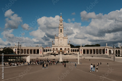 Wide view of Basilica of Our Lady of the Rosary and colonnade at Sanctuary of Fatima Portugal with blue sky and clouds iconic Catholic pilgrimage site and architectural landmark. High quality photo