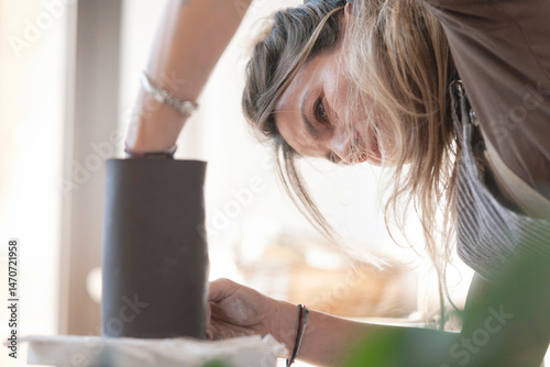 Woman potter preparing a ceramic bowl in an artisan workshop.