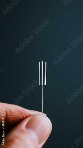 Close-up of a Hand Holding a Tiny Silver Fork Against a Dark Background