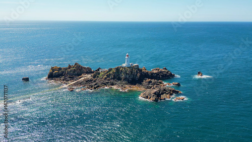 Fotografía Panoramic scenic aerial drone view of La Corbiere lighthouse on a rocky island surrounded by turquoise water