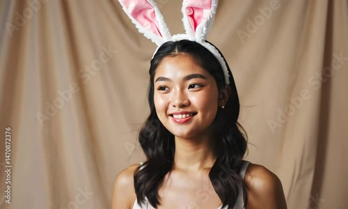 Young woman with bunny ears smiling portrait studio background