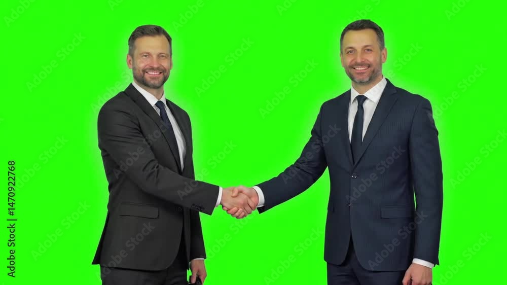 Two businessmen shaking hands with smile isolated on green screen Two businessmen shaking hands with smile isolated on green screen