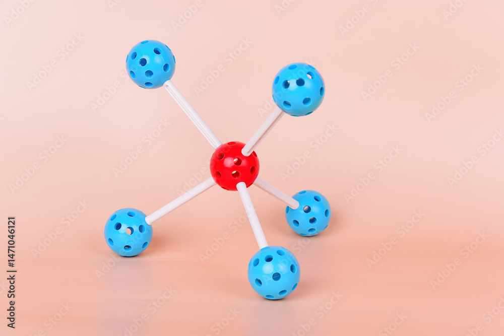Obraz premium Molecular model with a central red sphere and blue spheres connected by white rods, representing the structure of a molecule