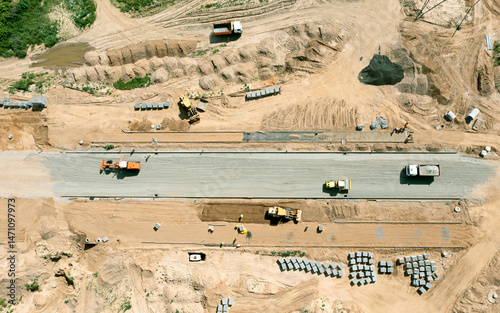 grader with roadroller flattening the ground during road construction. aerial top view from flying drone.