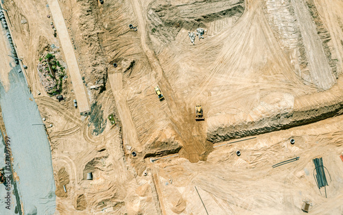construction site. yellow bulldozer and compactor prepare ground for future construction works. aerial top view.