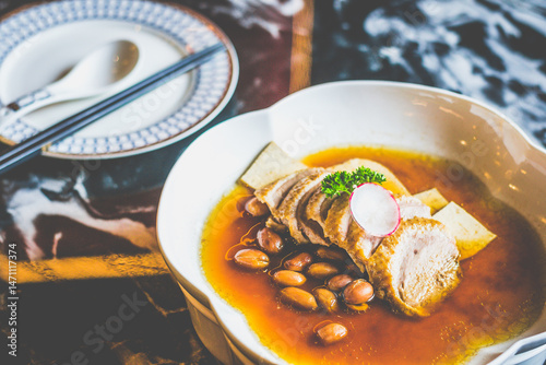 BRAISED DUCK with tofu slices and braised peanuts in a white dish
