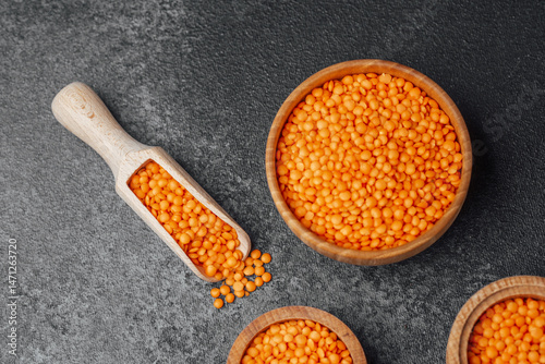 Obraz na płótnie Vibrant orange lentils displayed in wooden bowls on a dark surface w salonie