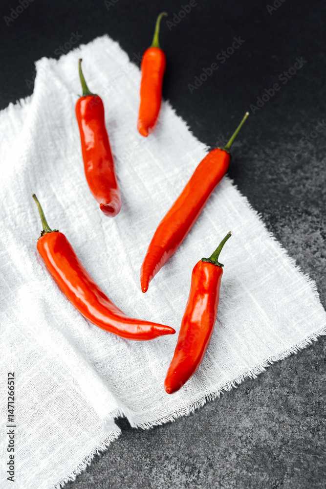 Bright red chili peppers arranged on a textured cloth background