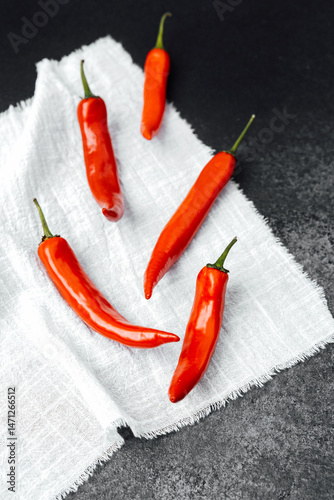 Obraz na płótnie Bright red chili peppers arranged on a textured cloth background w salonie