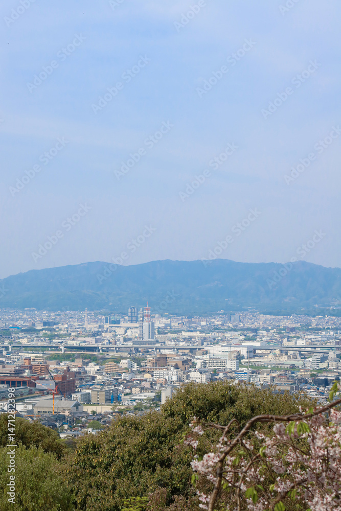 Fototapeta premium Kyoto, Japan – April 15, 2024: Panoramic view of Kyoto city and surrounding mountains from the summit of Mount Inari, along the path of Fushimi Inari Taisha, one of Japan’s most iconic landmarks.