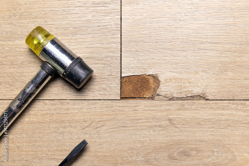 The Interlocking laminate floor is chip or crack due to scratches and impact. Repairing a damaged laminate floor concept. photo
