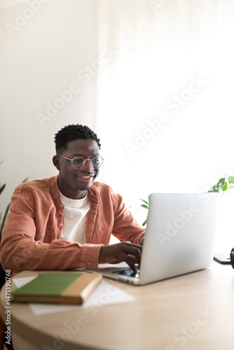 Smiling freelancer working from home on laptop