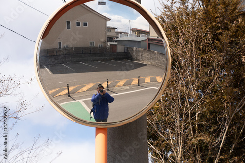 Tableau sur toile Photographer taking a self-portrait through a convex traffic mirror on a quiet street, capturing reflection on a sunny day