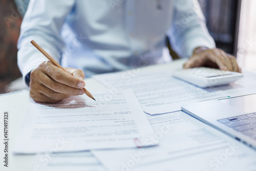 accountants working on desk checking accounting document, tax form and calculate business tax, close-up shot