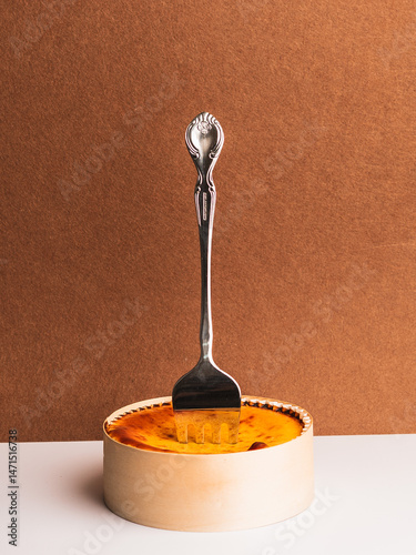 Elegant Fork in Creamy Cheesecake on Rustic Brown Background
