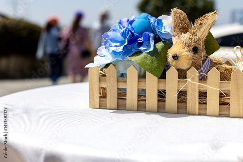 Easter decoration with bunny and blue flowers on table.