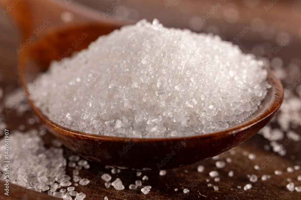 Granulated sugar in a spoon, detail macro photography of the granules Granulated sugar in a spoon, detail macro photography of the granules