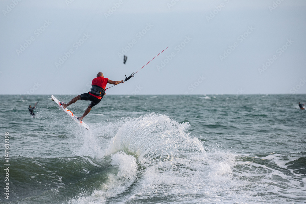 Obraz premium extreme kitesurfer riding a kite on the waves in the sea