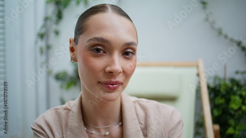 Closeup smiling woman looking camera with gentle smile in beige outfit portrait