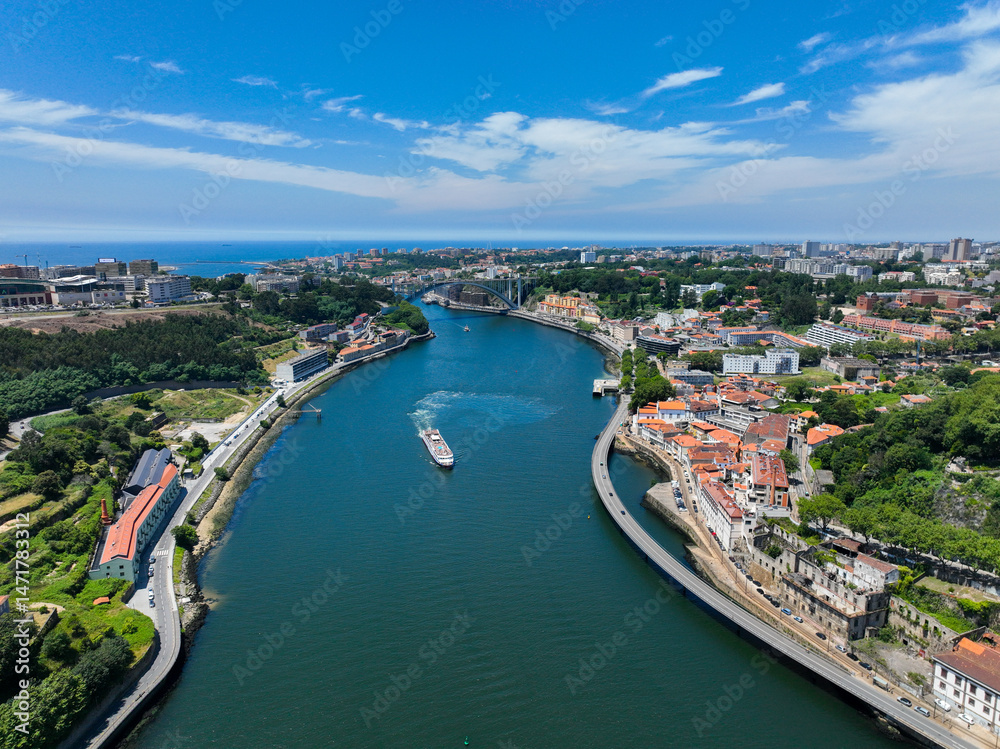 Obraz premium Wide aerial of the Douro River approaching the Atlantic with visible bridge