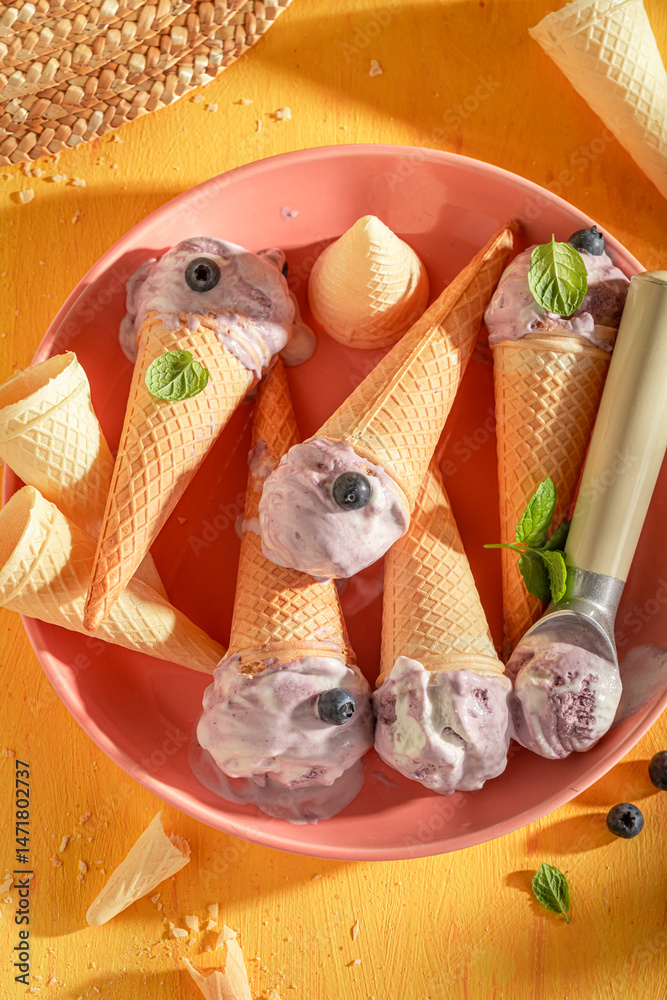 Homemade and tasty blueberry ice cream in a waffle cone.