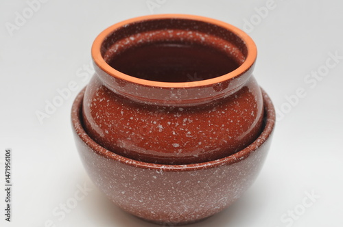 two brown ceramic pots one inside the other on a white background