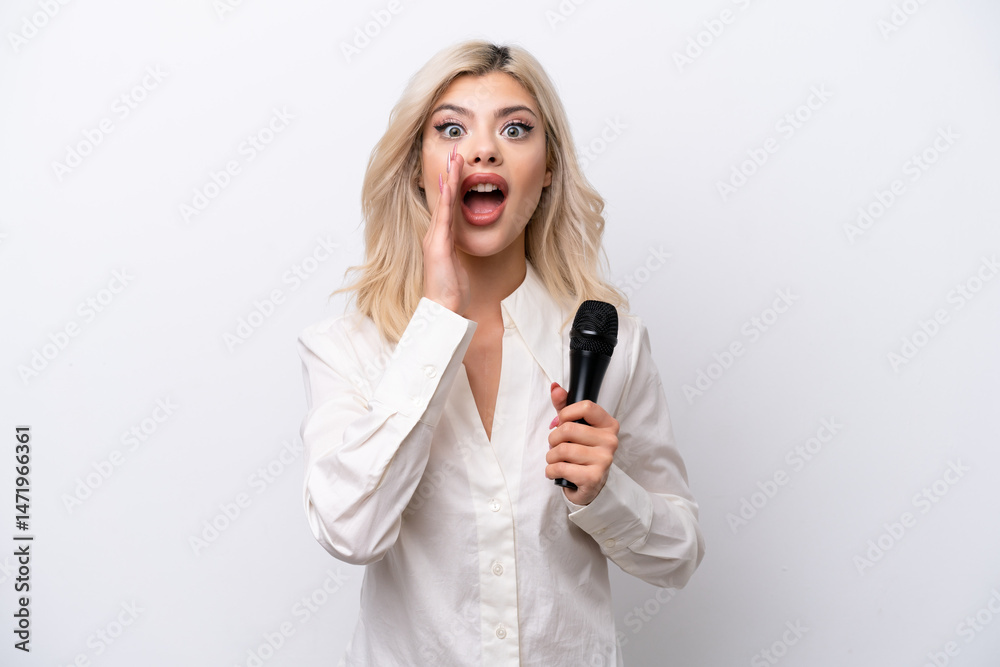 Young singer woman picking up a microphone isolated on white background with surprise and shocked facial expression Young singer woman picking up a microphone isolated on white background with surprise and shocked facial expression